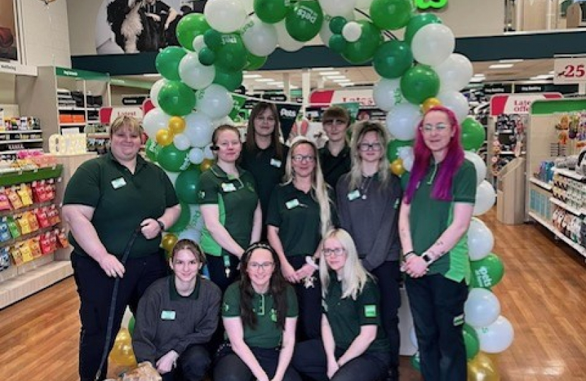 Staff members pose for photo in front of balloons